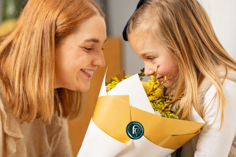 Madrinha e afilhada próximas a desfrutar de um lindo ramo de flores da Flores no Cais